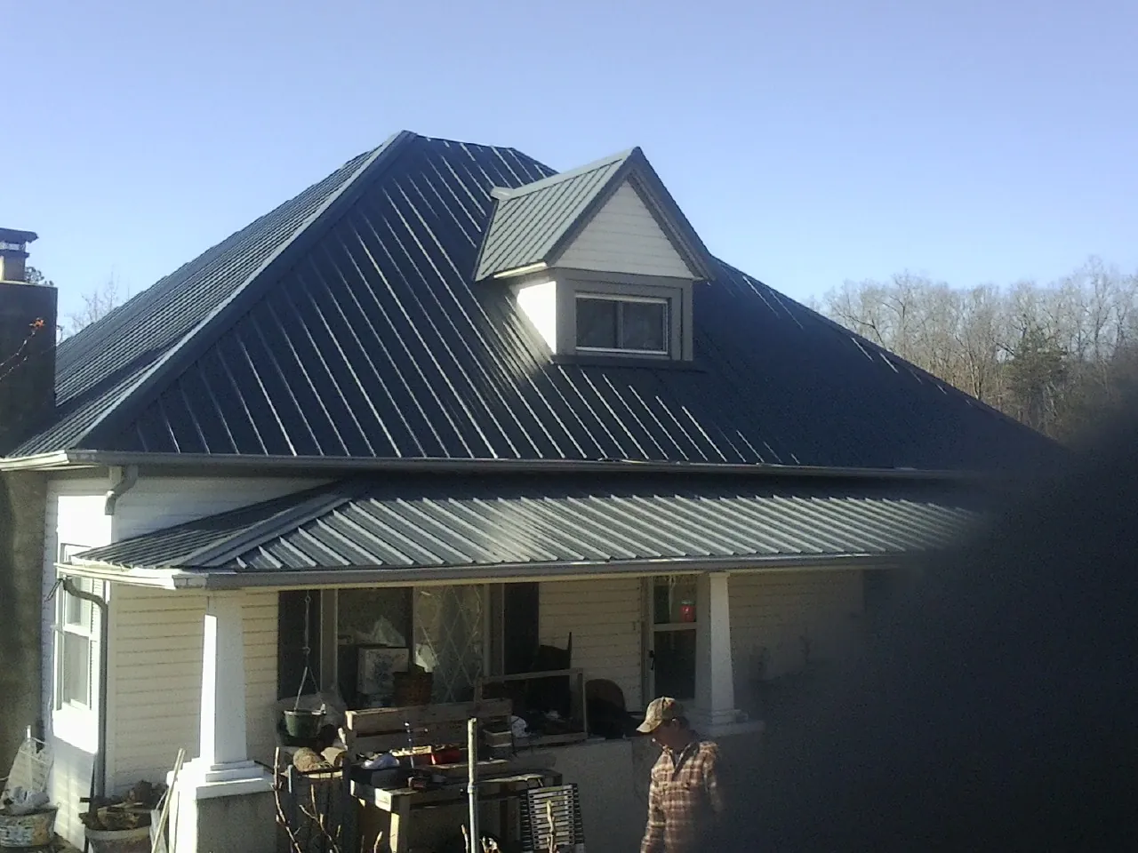 Dark blue standing seam metal roof with a dormer above a front porch in Port Monmouth