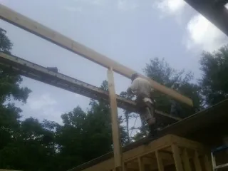 Carpenter setting a ridge beam over a new addition frame — Ice Dam Removal by Roofing Brothers in Port Monmouth