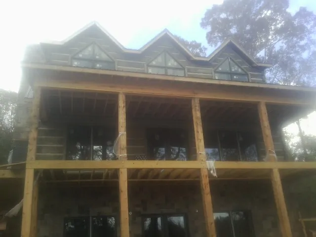 Dormers and porch framing on a large log home under construction — Roof Coating work by our crew in Port Monmouth