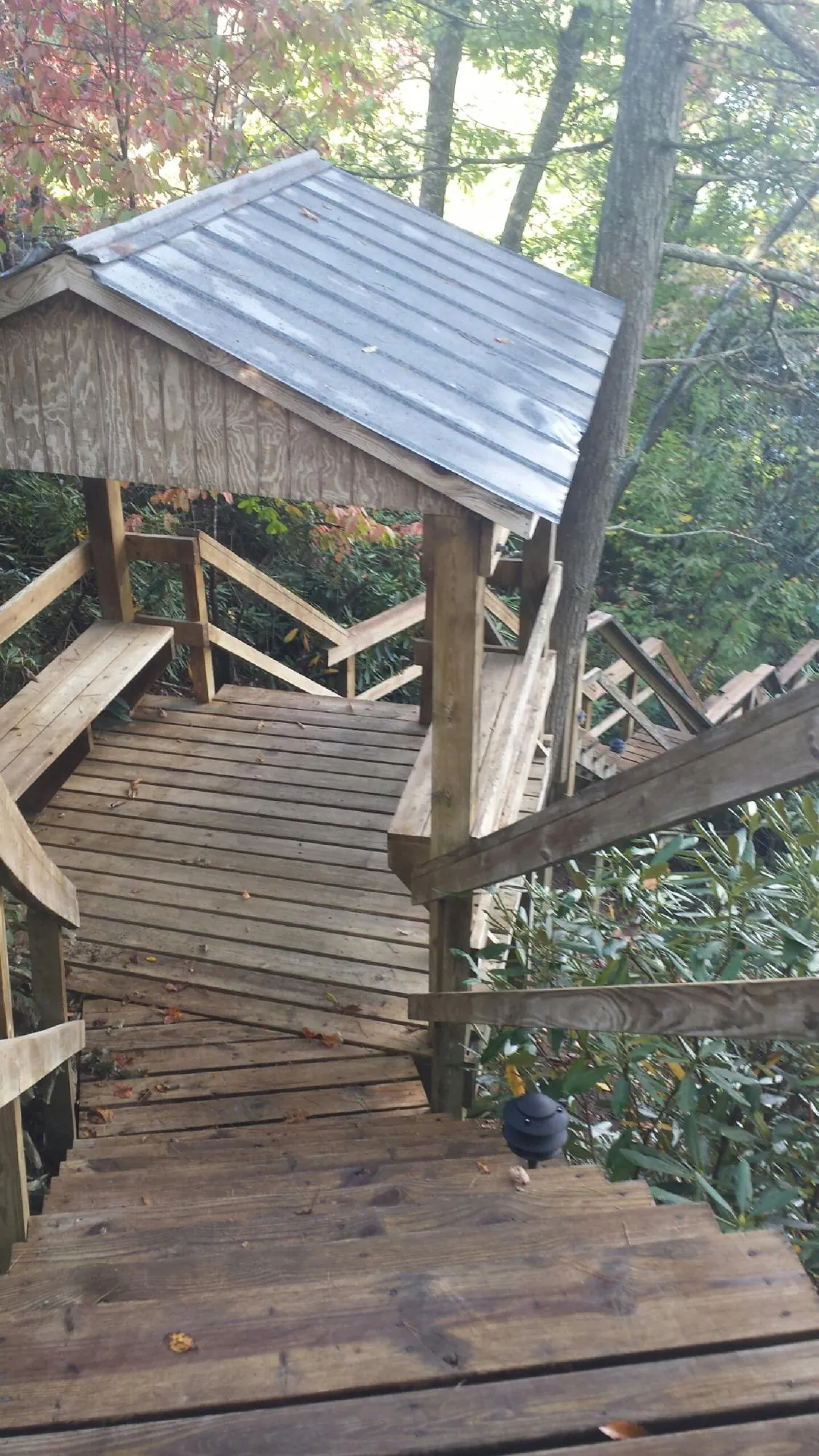 Metal roofed shelter over wooden steps on a wooded walkway — Skylight Repair & Installation work by our crew in Port Monmouth