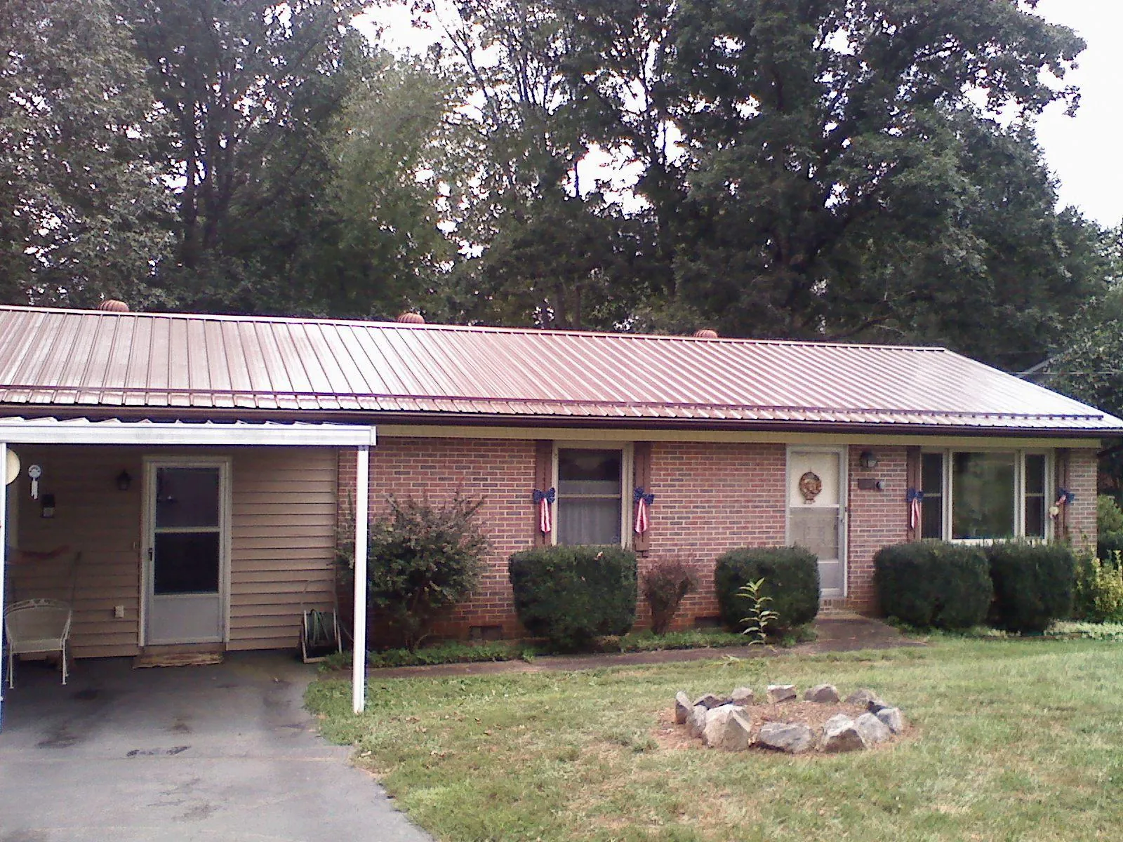 Bronze metal roof and carport on a brick ranch home — Roof Repair work by our crew in Port Monmouth